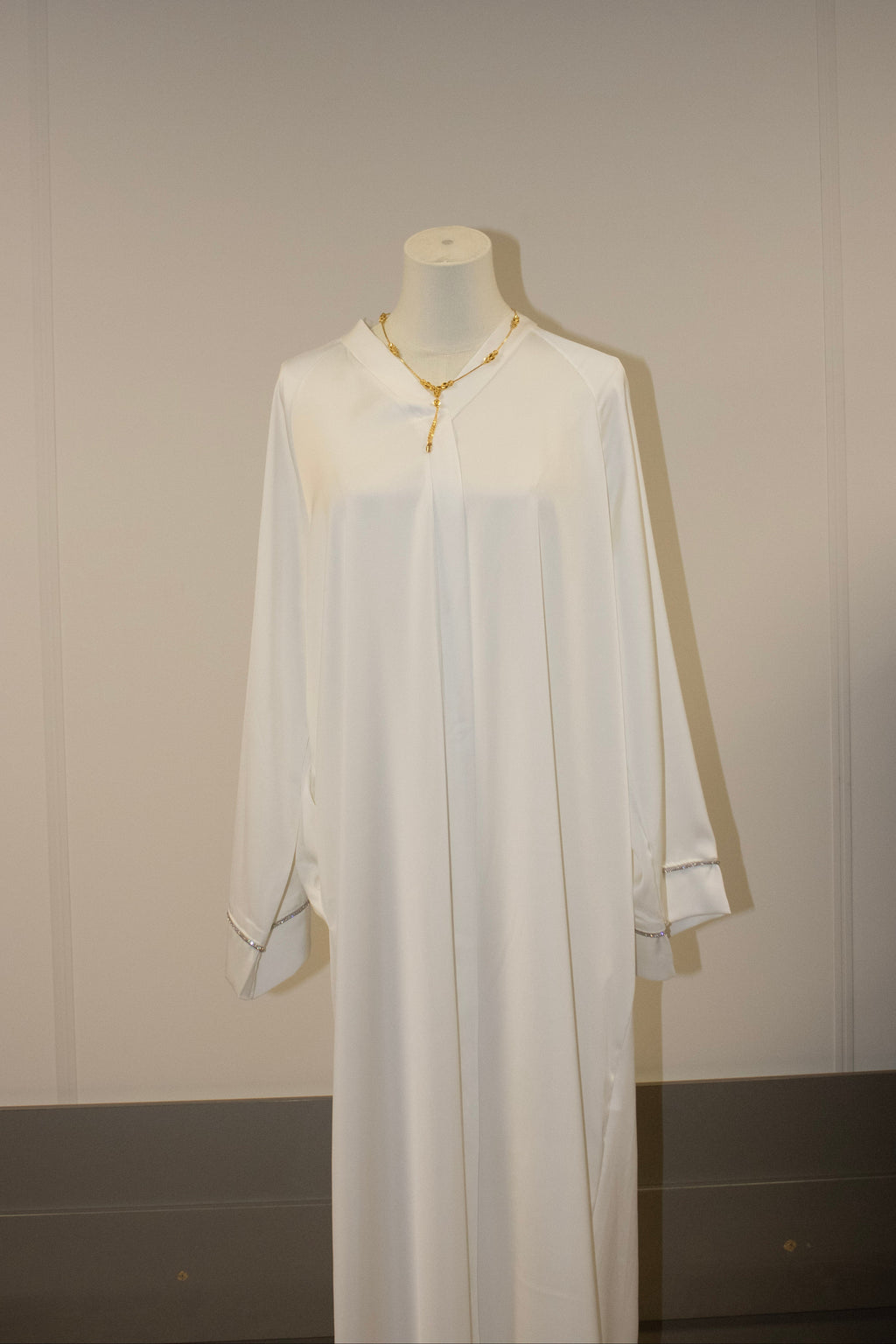 White dress on a mannequin against a plain background